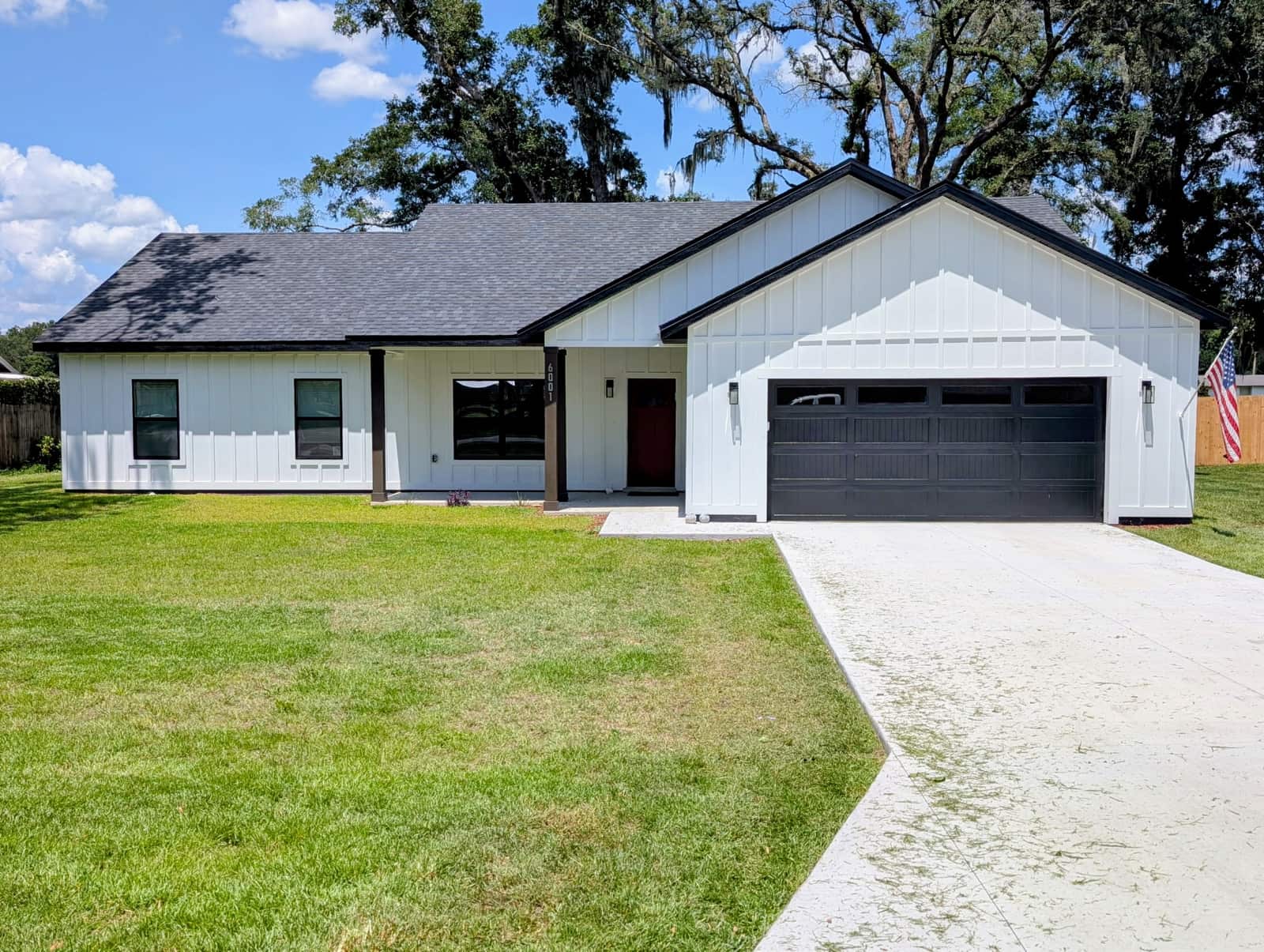 Newly painted white board-and-batten exterior with black trim on a new-construction home in Pepper Tree Estates, Ocala, FL